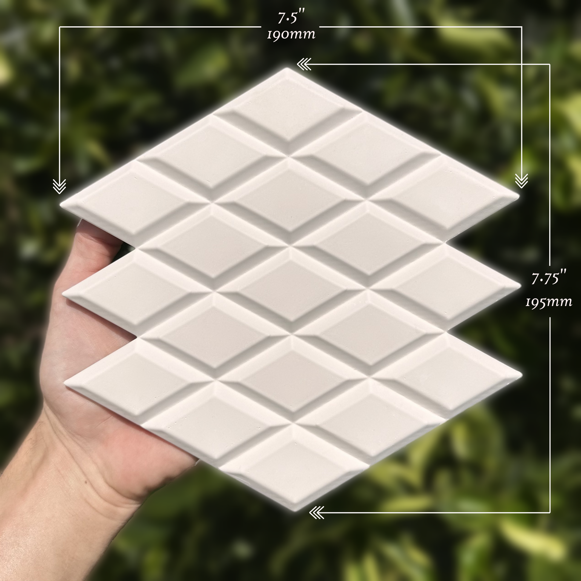 White ceramic tiles with geometric pattern held in a hand, with measurements indicated.